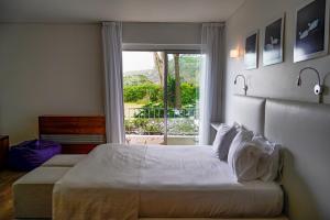a bedroom with a large bed with a window at ANC Resort in Caloura +184 photos