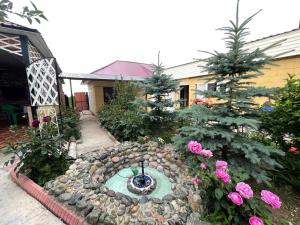 a garden with a fountain in the middle of a yard at Guest House Ugra in Barskoon