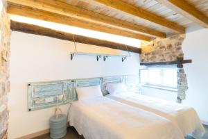 een slaapkamer met een groot wit bed en een stenen muur bij VUT Domus Aurea in Astorga