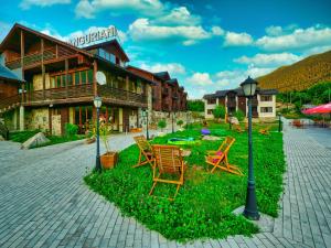 a group of chairs sitting in front of a building at Hotel Banguriani in Mestia