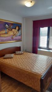 a bed in a bedroom with a painting on the wall at Apartma pri Gradu in Brežice