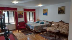 a bedroom with a bed and a couch and a table at Apartma pri Gradu in Brežice