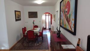 a dining room with a table and red chairs at Apartma pri Gradu in Brežice