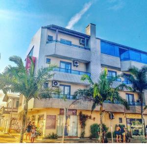 un edificio con palmeras delante en Hotel Costa Dalpiaz, en Torres