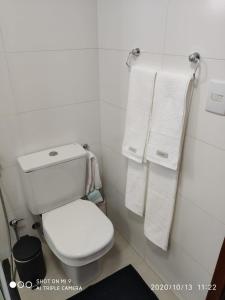 y baño con aseo blanco y toallas. en Flat Unique Moderno & Luxuoso en Ribeirão Preto