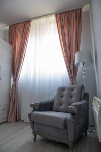 a living room with a couch and a large window at DIS apartman 1 in Kruševac