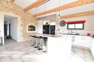 cocina con encimeras blancas y pared de piedra en Mas typique en pleine camargue, en Le Cailar