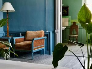 a living room with blue walls and a chair at 1900 Hotel in Symi