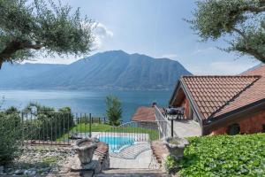 ein Haus mit Blick auf einen Wasserkörper in der Unterkunft Villa privata con piscina Colonno in Colonno