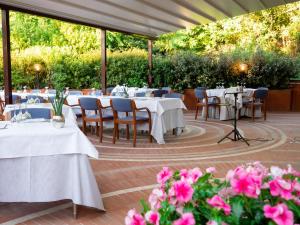a dining room table with chairs and umbrellas at Hotel Minerva in Arezzo