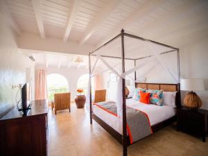 1 dormitorio con cama con dosel y TV en Windjammer Landing Resort and Residences, en Gros Islet