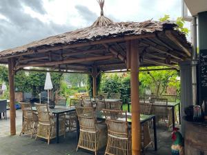 um gazebo de madeira com mesas e cadeiras num quintal em zu Jeddelohs Lodge Hotel em Gladenbach