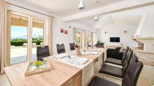 a dining room with tables and chairs and a fireplace at Villa Melli in Vižinada