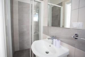 y baño blanco con lavabo y ducha. en Serious Job Room, en Dubrovnik
