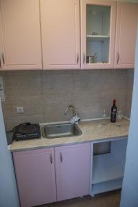 a kitchen with white cabinets and a sink at DIS apartman 1 in Kruševac