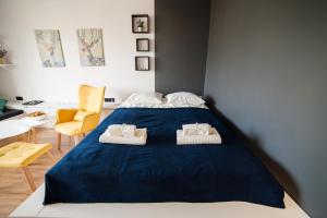 a bedroom with a blue bed with towels on it at Apartament ZDROJOVY in Busko-Zdrój