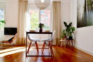 ein Wohnzimmer mit Tisch und Stühlen und einem Fenster in der Unterkunft Hola Valencia - Holiday Apartments in Valencia