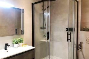 a bathroom with a glass shower with a sink at Hola Valencia - Holiday Apartments in Valencia