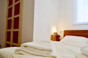 ein Schlafzimmer mit einem Bett mit weißen Laken und einem Fenster in der Unterkunft Hola Valencia - Holiday Apartments in Valencia