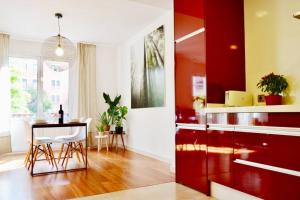una cocina con armarios rojos y una mesa en una habitación en Hola Valencia - Holiday Apartments, en Valencia