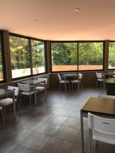 a restaurant with tables and chairs and windows at Les Papoulis in Saint-Laurent-sur-Sèvre