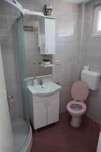 a bathroom with a pink toilet and a sink at DIS apartman 1 in Kruševac