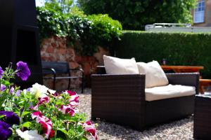 キャンベルタウンにあるGowanlea Heightsの花が咲くパティオに置かれた籐の椅子と枕