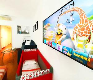 a tv on a wall with a picture of a giraffe at Room Inn in Milan