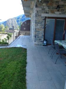 eine Terrasse mit einem Tisch und Stühlen neben einem Gebäude in der Unterkunft Apartment Rosa Dei Venti in Gravedona