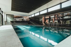 a woman walking by a swimming pool at Hotel Elisabeth in Mechelen