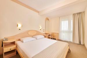 a hotel room with a bed and a window at Hotel Istra Plava Laguna in Poreč