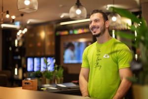 a man in a green shirt standing in a restaurant at the niu Yen in Hamburg