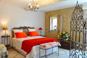 a bedroom with a bed with red pillows at Fontaine des Magnarelles in Althen-des-Paluds