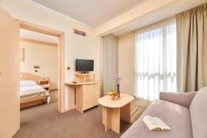 a hotel room with a couch and a television at Hotel Istra Plava Laguna in Poreč