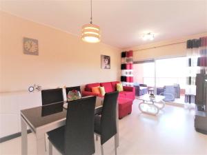 a living room with a red couch and a table at Summer Beach Apartment litoralmar in Portimão