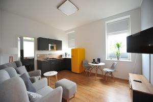 a living room with a couch and chairs and a kitchen at Appartm. Schwarzen Pfuhl in Willich