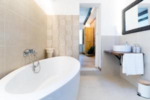 een badkamer met een wit bad en een spiegel bij VUT Domus Aurea in Astorga