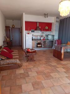 a living room with a kitchen with red walls at Casa Vacanze Monte Argentario in Porto Santo Stefano