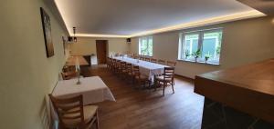 una sala da pranzo con tavoli, sedie e finestre di Hotel-Restaurant Elsterblick a Elsteraue