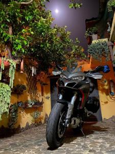 uma moto estacionada em frente a um edifício com plantas em B&B Annalu' em Guspini