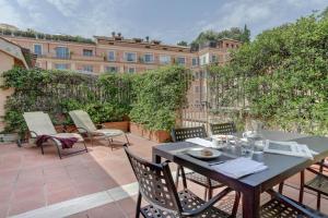 eine Terrasse mit einem Tisch und Stühlen sowie ein Gebäude in der Unterkunft Piazzetta Margutta - My Extra Home in Rom