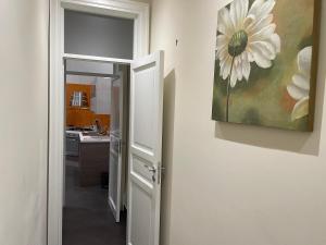 una cocina con una pintura de una flor blanca en la pared en Appartamento Cavour in centro en Palermo