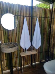 a bathroom with two white towels hanging on a fence at Ecoglamping Reserva Natural Paraíso Andino in La Vega