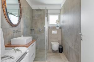 un bagno con lavandino, WC e specchio di Nevera Apartment a Trogir Altre 35 foto