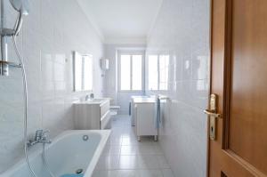 un bagno bianco con vasca e lavandino di Onda Blu ad Alghero