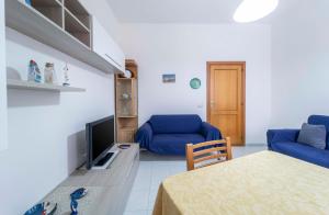 阿尔盖罗Onda Blu的客厅里有一张蓝色沙发和一台电视