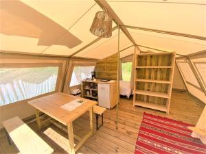 een tent met een tafel en een bureau. bij Les Bastides de Chanteraine Hôtel de plein air & spa in Aiguines