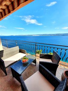 a balcony with chairs and a table with a view of the ocean at Apartment ZaDoDa in Omiš