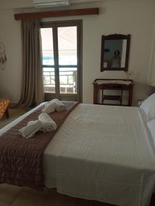 a bedroom with a large bed with towels on it at Buganvilla Sea View apts in Agia Pelagia