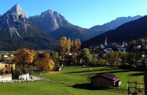 a small town in a field with mountains in the background at Appartements Sam in Lermoos